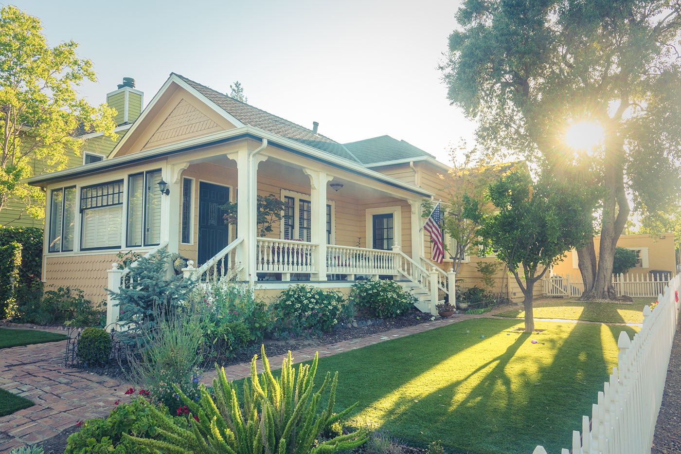 Traditional American home with a front porch and landscaped yard